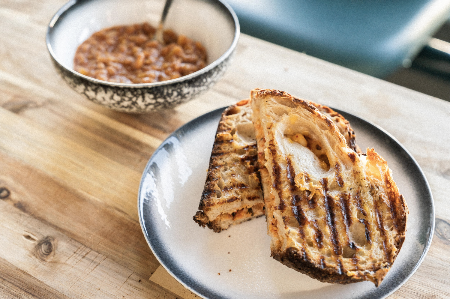 Image showcasing Motherlove kombucha's grilled kimcheese sandwich with Hawaiian-style baked beans as a side from their vegan menu