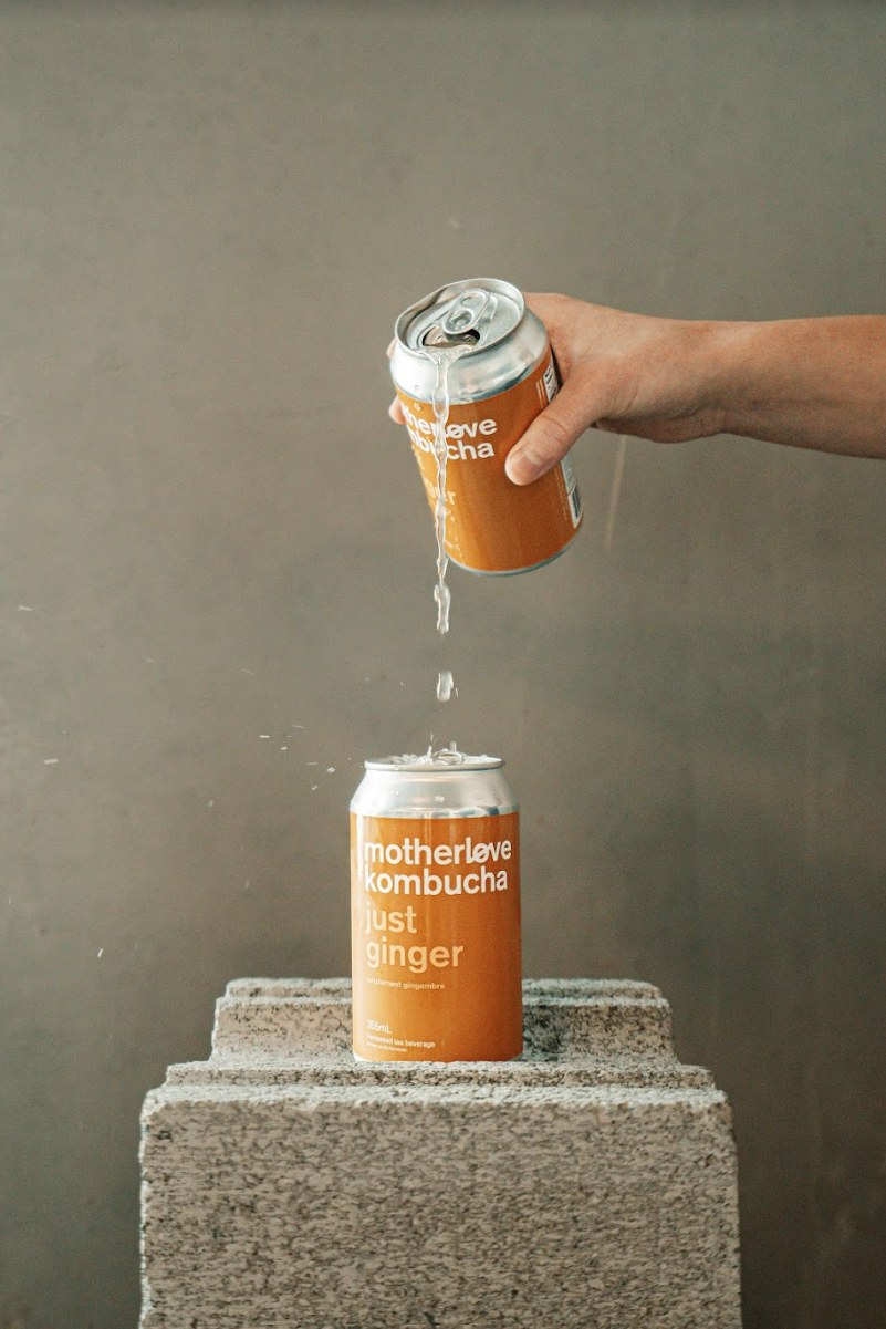 Motherlove ferments just ginger kombucha being poured from one can into another. When photo is clicked a promo video of our new cans plays.